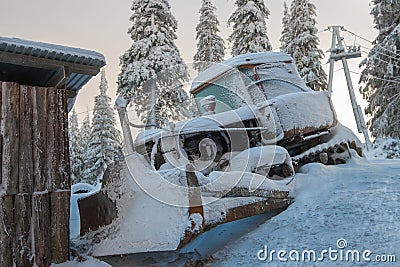 Dawn over a bulldozer covered with snow. Stock Photo