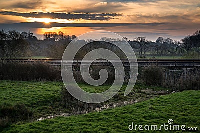 Dawn over railway tracks through countryside landscape Stock Photo