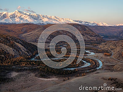 Dawn over a winding river in a mountain valley. Autumn landscape of Kurai steppe with Chuya river, mountain forest of Siberia Stock Photo