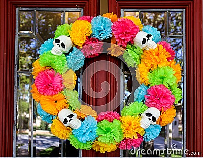 Day of the Dead wreath on door with tree and neighborhood reflected in beveled glass window Stock Photo