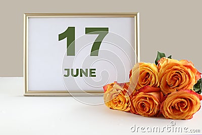 Day of the month 17 June calendar photo frame and yellow rose on a white table Stock Photo