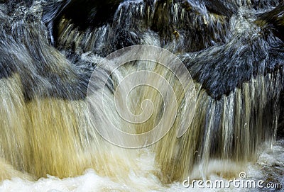 Tannins turn a waterfall amber in Colchester, Connecticut in autumn Stock Photo