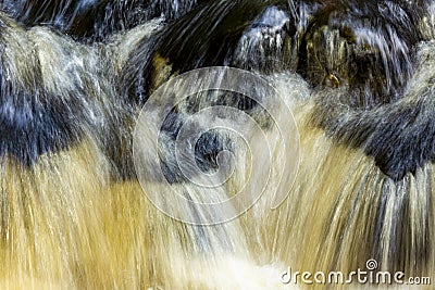 Tannins turn a waterfall amber in Colchester, Connecticut in autumn Stock Photo