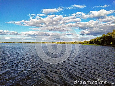 Day surface of the lake with beautiful cumulus clouds. Stock Photo