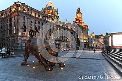 Day view of the Bund of Shanghai and the bronze bull and some tourists passing by Editorial Stock Photo