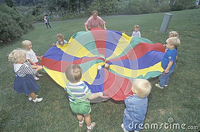 Daycare children playing a parachute game Editorial Stock Photo