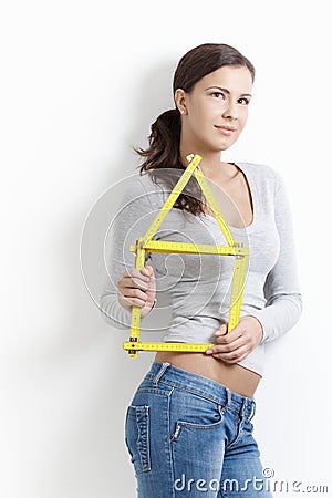 Daydreaming woman posing with folding rule Stock Photo