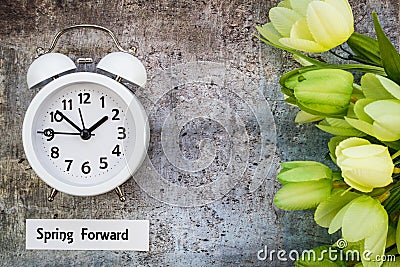 Daylight Savings Time Spring Forward concept top down view with white clock and green tulips Stock Photo