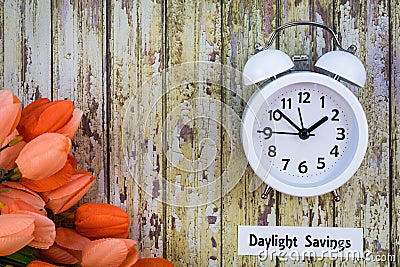 Daylight Savings Time Spring concept top down view with white clock and orange tulips Stock Photo