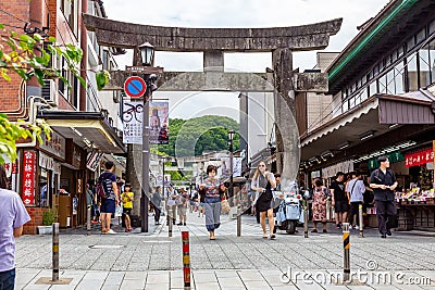 Tourists and local japanese people walk along the main road, surrounded by shops, leading to the famous Tenmangu Shrine in Dazaifu Editorial Stock Photo