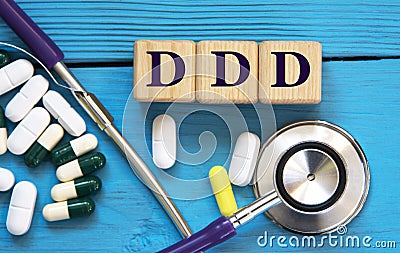 DDD - acronym on wooden cubes on a blue background with a stethoscope and tablets Stock Photo