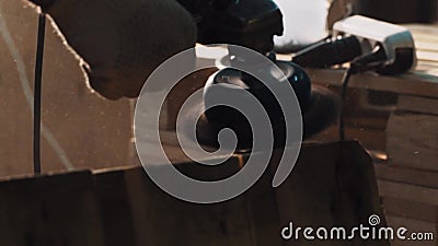 De arbeider dient de molenmachine van het handschoengebruik aan vlotte houten palletranden in stock footage De arbeider dient de molenmachine van het handschoengebruik aan vlotte houten palletranden in stock footage