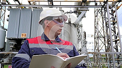 De energieingenieur inspecteert de apparatuur van het substation. energiezuinigheid. industrie stock footage De energieingenieur inspecteert de apparatuur van het substation. energiezuinigheid. industrie stock footage