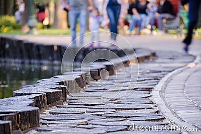 De-focus or blurred photo with people walking along the paved sidewalk in the park. Stock Photo