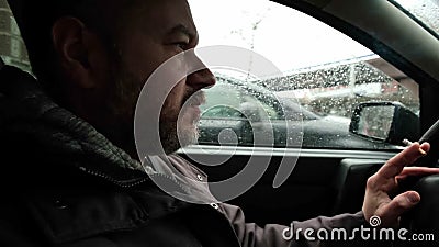 De man bestuurt een auto. gewone man met een baard die een auto bestuurt. ernstige kijkconcentratie stock video De man bestuurt een auto. gewone man met een baard die een auto bestuurt. ernstige kijkconcentratie stock video