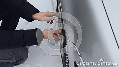 De mens verwijdert een wieldeksel van een plastic wieldop uit zijn auto in de winter overdag Slecht en koud weer Sluiting storing stock video De mens verwijdert een wieldeksel van een plastic wieldop uit zijn auto in de winter overdag Slecht en koud weer Sluiting storing stock video