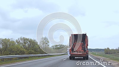 De vuilnisauto beweegt zich langs de weg, de auto die huisvuil drijft langs de weg draagt stock video De vuilnisauto beweegt zich langs de weg, de auto die huisvuil drijft langs de weg draagt stock video