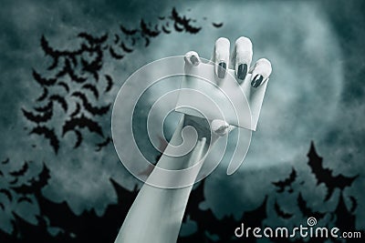 Dead hand with blank card in Halloween night, copy-space. Stock Photo