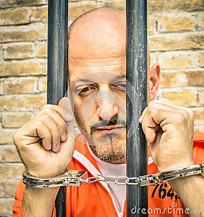 Dead Man Walking - Sad Prisoner with Handcuffs behind Bars Stock Photo