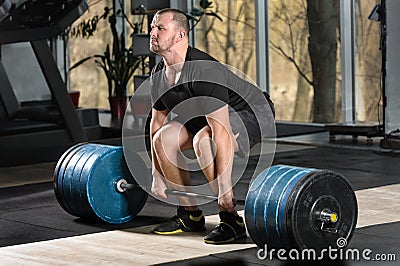 Deadlift attempt. Young man trying to lift heavy barbell Stock Photo