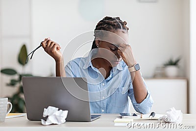 Deadline Stress. Overworked Black Female Entrepreneur Massaging Nosebridge At Workplace In Office Stock Photo