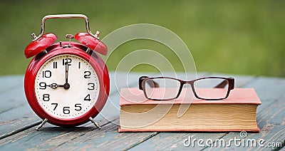 Deadline, time concept, alarm clock with book and eyeglasses Stock Photo