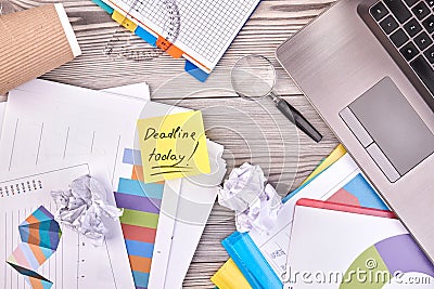 Deadline today concept. Many office stuff on white wooden desk. Stock Photo