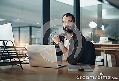 Deadlines dont scare me. a young businessman using a computer during a late night in a modern office. Stock Photo