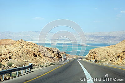Deadseaview on a curvy sandy road on a highway that runs along the Dead Sea from one side and Edom Mountains at Arava Desert from Stock Photo