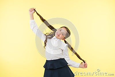 Deal with long hair hairstyle by yourself. Kid girl long ponytail hairstyle. Child school uniform make hairdo. Kid Stock Photo