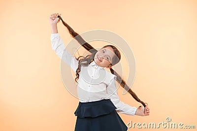 Deal with long hair hairstyle by yourself. Kid girl long ponytail hairstyle. Child school uniform make hairdo. Kid Stock Photo