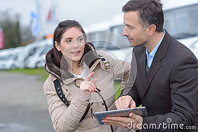 Dealer and female customer buying caravan Stock Photo