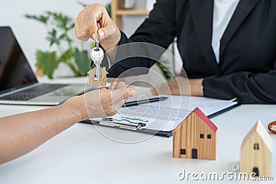 The dealer is sending the house key to the new owner after agreeing to the contract to buy-sell the house. Rent house and buy conc Stock Photo