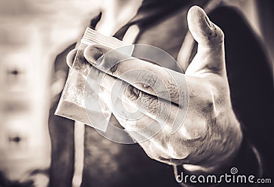 Dealing Illegal Drugs By A Man Holding A Little Bag With White Powder In His Hand In Monochrome Colors Stock Photo