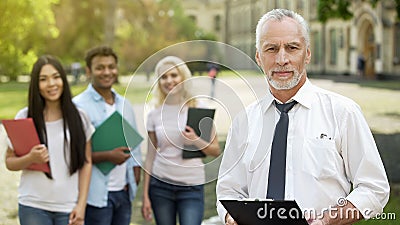 Dean and group of students looking into camera, college education opportunities Stock Photo