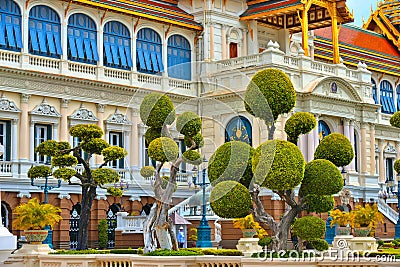 Deatail of beautiful plants with strange shapes in front of Grand Palace court and Chakri Maha Prasat building with ro Editorial Stock Photo