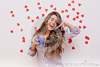 Debonair woman with dark-brown hair smiling in morning. Indoor photo of adorable european girl holding mug with coffee Stock Photo