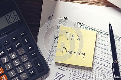 Debt collection and tax planning with deadline calendar reminder note, U.S. tax form 1040, calculator on wooden background. Top Editorial Stock Photo