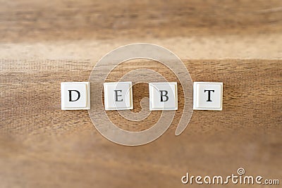 The word Debt on a wooden background. Stock Photo