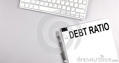 DEBT RATIO text on paper with keyboard on grey background Stock Photo