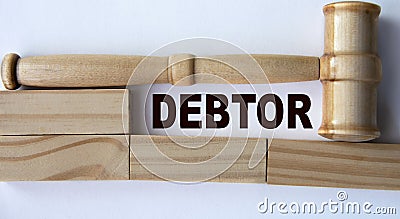 DEBTOR - word on the background of wooden blocks and a judge's gavel Stock Photo