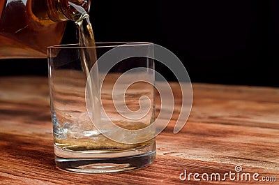 From a decanter, whiskey is poured into a glass Stock Photo