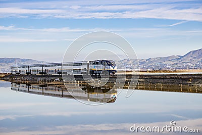 December 6, 2016, Alviso, San Jose, California, USA - Amtrak train passes through Alviso marsh on a sunny day Editorial Stock Photo