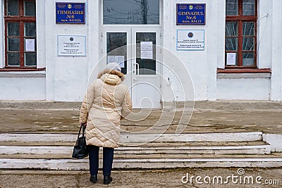 December 5, 2021 Beltsy, Moldova. The back of a woman going to the polls. A polling station in a typical school Editorial Stock Photo