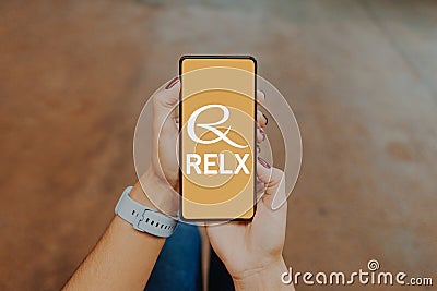 December 20, 2023, Brazil. In this photo illustration, the RELX Group logo is displayed on a smartphone screen Cartoon Illustration