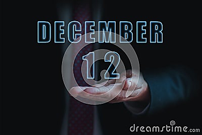 december 12th. Day 12 of month, announcement of date of business meeting or event. businessman holds the name of the month and day Stock Photo