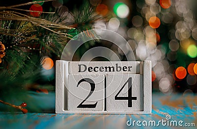 December 24 th on wooden cube with christmas tree lights background. Christmas eve concept Stock Photo