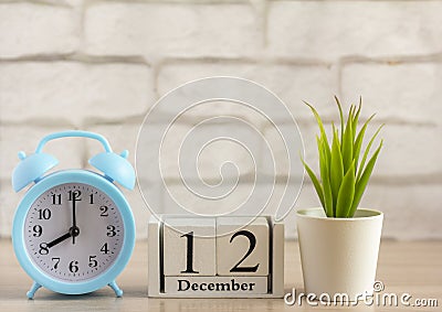 December 12 on the wooden calendar next to the alarm clock, the first day of the first winter month Stock Photo