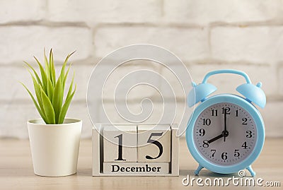 December 15 on the wooden calendar next to the alarm clock, the first day of the first winter month Stock Photo