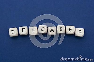 December lettering. Wooden blocks with december word over clasic blue blackground. Copy space Stock Photo